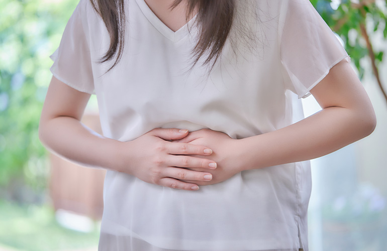 お腹をおさえる女性